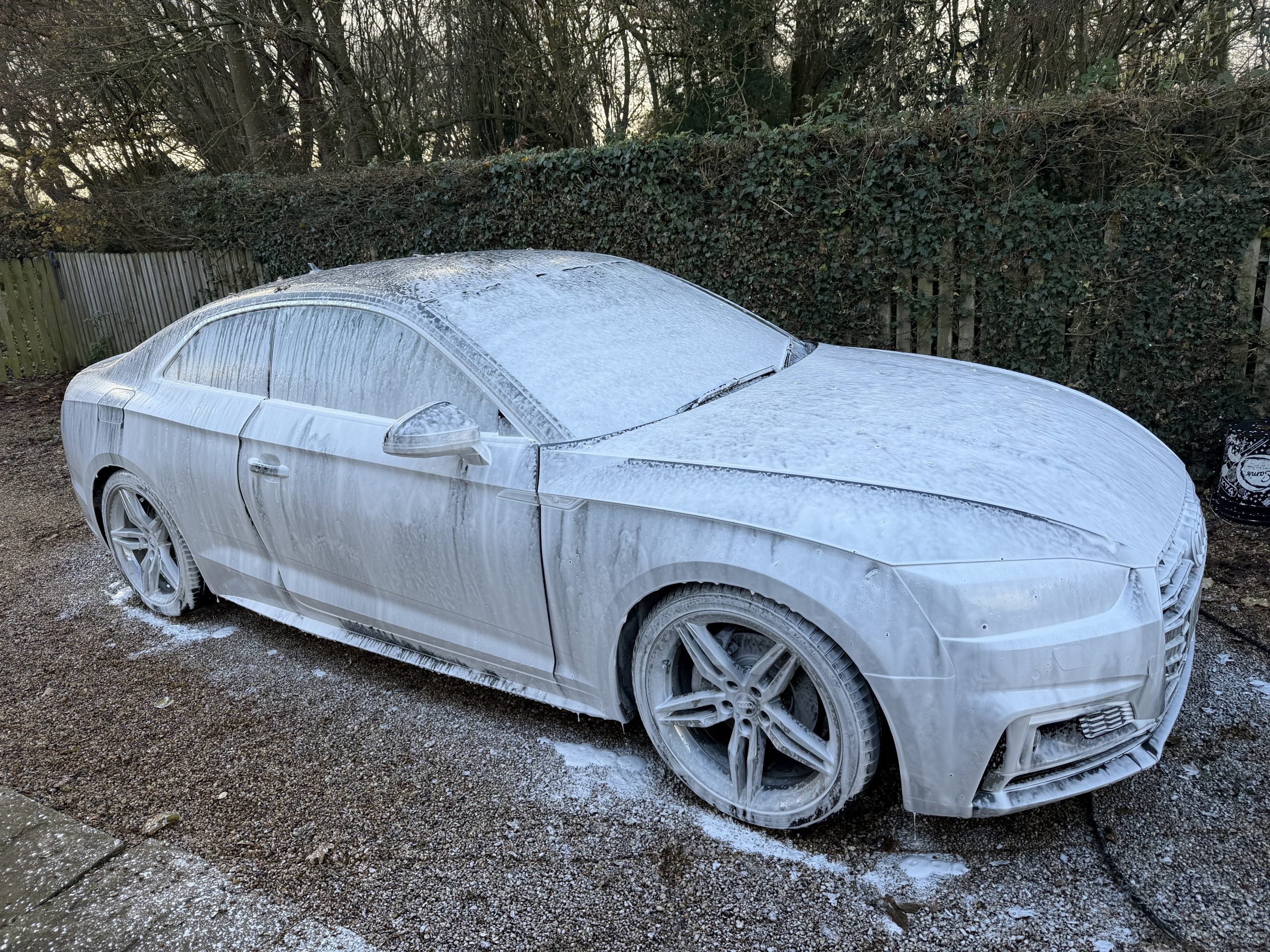 Car covered in premium snow foam during deep clean